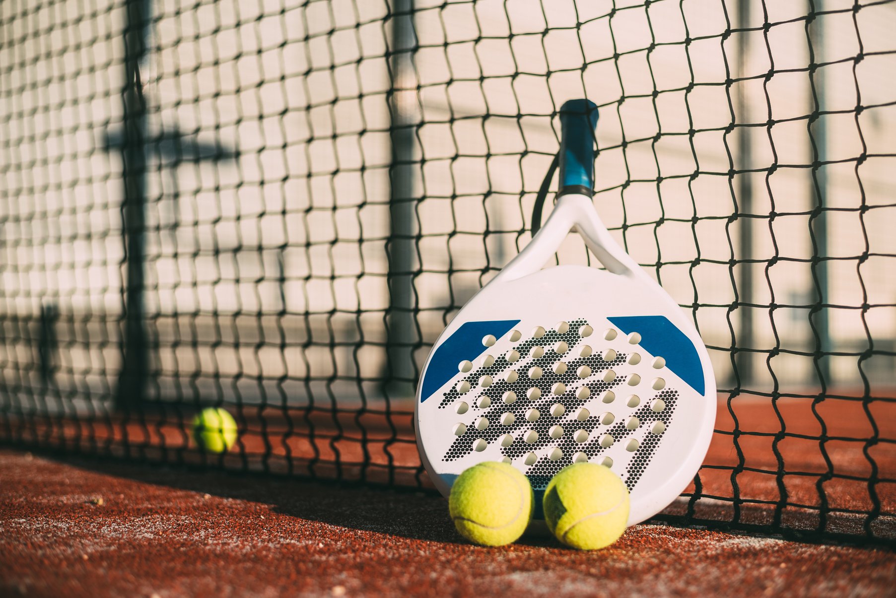 Padel blade racket resting on the net